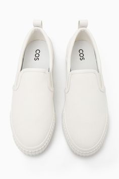 These slip-on trainers are an easy option for summer dressing – they'll go with all your casual outfits but will work equally well to pare back tailoring, too. Crafted from cotton-canvas with leather detailing, they come in versatile white and have chunky rubber soles and elasticated inserts for comfort. The leather pull tab at the back makes them easy to slip on and off. Leather binding and panellingRecycled cotton is made by converting both pre- and post-consumer fabric into fibres that are then spun into new yarn Shell & Lining: 80% Cotton, 20% Recycled cotton, Sole: 80% Rubber, 20% Recycled rubber Casual White Slip-on Platform Sneakers, White Slip-ons With Rubber Sole For Summer, White Textile Slip-ons With Textured Sole, Spring Cotton Slip-on Sneakers With Rubber Sole, White Textured Sole Slip-ons For Streetwear, Sporty Slip-ons For Streetwear In Spring, Sporty Spring Slip-ons For Streetwear, Sporty White Slip-ons With Rubber Sole, White Sporty Slip-ons With Rubber Sole