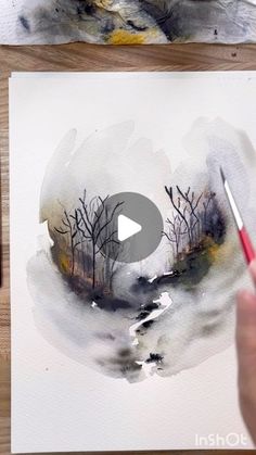 someone is painting a landscape with watercolors