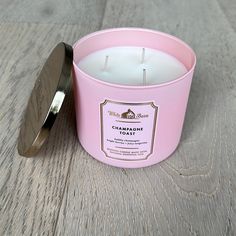 a pink candle sitting on top of a wooden table