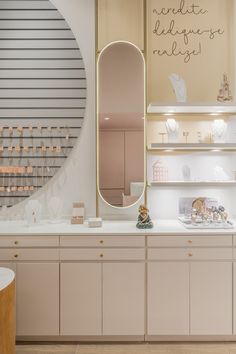 a white counter top sitting next to a wall filled with shelves covered in candles and other items