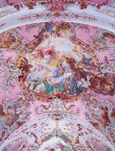 an ornate ceiling with paintings on it in a room filled with pink and white walls