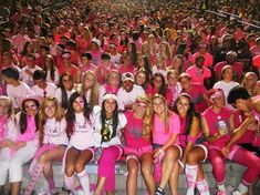 a group of women in pink shirts and white shorts posing for a photo with each other