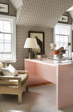 a living room with pink furniture and wallpaper