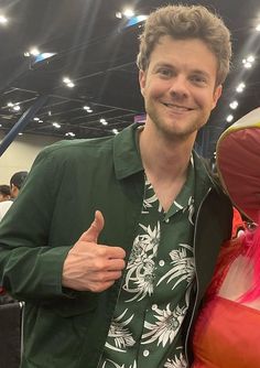 a man standing next to a woman in a green shirt