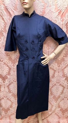 Vintage 1950s Classic "Hot Secretary" Navy Blue Hour-Glass Wiggle Dress with Decorative Tab Front accented with Donut Buttons & Two Slash Front Hip Pockets. 3/4-Length Raglan sleeves, Full Rear Metal Zipper, Partial Cotton liner in the skirt. The Fabric feels like a smooth silky blend of cotton and rayon, almost like a polished cotton but I believe there's a hint of rayon in the weave, there is a slub in the weave similar to shantung. Dress is likely Deadstock, from the estate of the ultimate pa Wiggle Dress, Pencil Dress, Vintage 1950s, Raglan Sleeve, Navy Blue, High Neck Dress, Shirt Dress, Navy, Silk