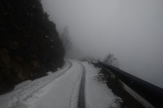 the road is covered in snow and fog