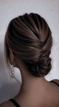 the back of a woman's head, with her hair in a low bun