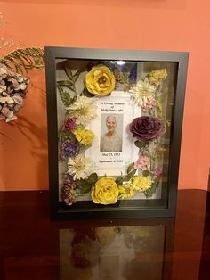 a photo frame with flowers in it on a table