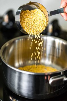 a person is pouring mustard into a pan on the stove