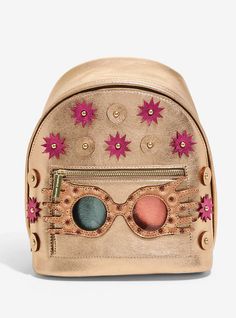 a gold backpack with pink flowers and stars on the front, sitting against a white background