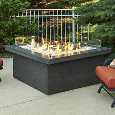 an outdoor fire pit with two chairs around it