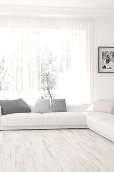 a large white couch sitting in a living room on top of a hard wood floor