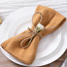 a white plate topped with a napkin and a flower