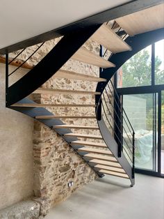 a spiral staircase in a house with stone walls