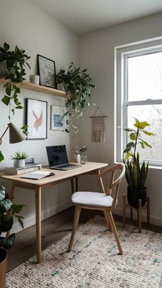 a desk with a laptop on it next to a potted plant and a window