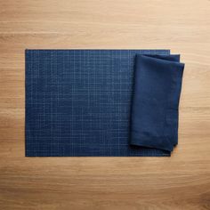 two pieces of cloth sitting on top of a wooden table next to a knife and fork