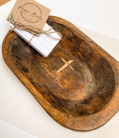 a wooden tray with a notepad on top of it and a tag tied to the edge