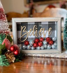 a christmas scene with ornaments and a framed believe sign