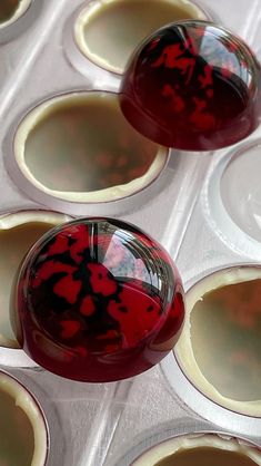 red and white marbles sitting on top of each other in muffin tins