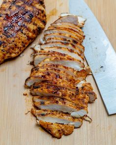 the meat is cut up and ready to be served on the grilling board with a knife