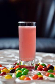 a glass filled with candy sitting on top of a table