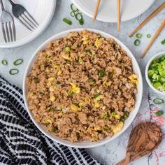 rice and vegetables in a bowl with chopsticks next to it on a table