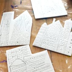 some white paper cut outs sitting on top of a wooden table next to each other