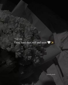 a bouquet of white flowers sitting on top of a table next to a quote that reads, these hard days will end soon