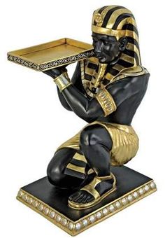 an egyptian figurine holding a tray with jewels on it's lapel