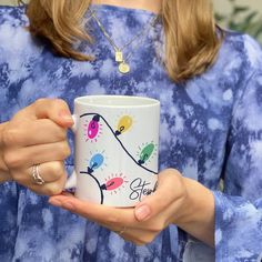 a woman is holding a coffee mug in her hands