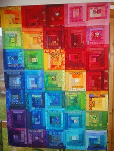 a colorful quilt hanging on the side of a window