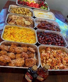 many trays of food are arranged on a table