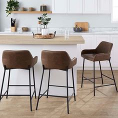 three brown bar stools sitting on top of a kitchen counter