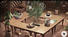 a wooden table surrounded by potted plants on top of hard wood flooring in a room