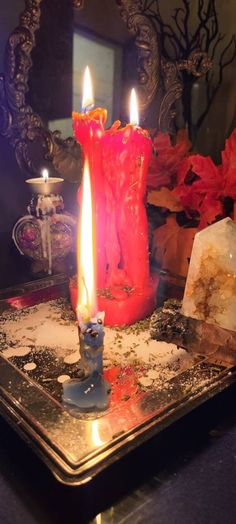 two candles sitting on top of a metal tray