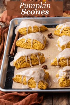 pumpkin scones on a baking sheet with icing drizzled