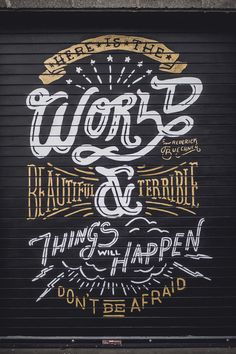 a garage door painted with words and phrases on it's black background that says work & beauty is terrible, things happen don't be afraid