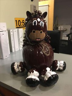 a large chocolate apple sitting on top of a counter next to some white frosting