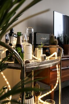 a bar cart with bottles and glasses on it