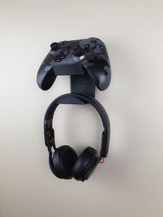 a video game controller mounted to the wall with headphones on it's side