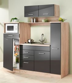 a kitchen with an open refrigerator next to a sink and microwave oven in it's cabinet