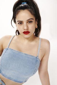 a woman in a denim top with red lipstick on her lips, posing for the camera