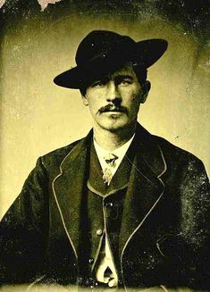 an old black and white photo of a man wearing a hat