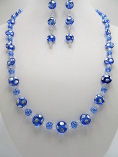 "This necklace set is made with beautiful sapphire Czech glass lentil beads. The flat round beads are covered with silver polka dots and separated with 4mm crystal bicones and 6mm clear blue rounds. The earrings dangle 2.5\" from the loops of the silver plated ear wires. The 7.5 inch bracelet is adjustable to 8.5 inches. This 3 piece set will be slipped into an organza bag and shipped in a bubble mailer." Silver Czech Glass Round Necklace, Round Silver Czech Glass Necklace, Adjustable Blue Czech Glass Jewelry, Blue Crystal Jewelry With Polished Beads, Silver Beaded Round Jewelry Sets, Silver Beaded Jewelry Sets, Blue Round Czech Glass Jewelry, Blue Polished Beads Round Jewelry, Blue Jewelry With Polished Round Beads