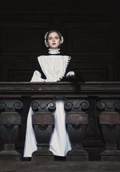 a woman sitting on top of a wooden bench