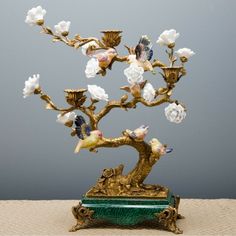 a gold tree with white flowers and birds on it