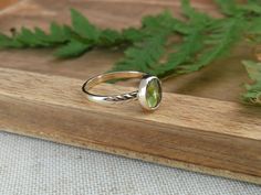 This nature inspired solid gold ring features a beautiful bright green peridot. On one side of the stone the band is adorned with carved leaves, on the other side the band is adorned with a gold ball. The ring band is made out of 1mm thick 14k gold and is about 2 mm wide. Details: - this ring measures a US size 6.25 (16.75mm)  - the peridot measures about 9mm x 6.5mm - the band is approximately 2mm wide and is 1mm thick - the material used recycled 14k solid gold You will receive the exact item as pictured, but please note that colors may vary slightly depending on the screen you are using. This jewel is made with care and much love and will be packaged accordingly. Whether you will buy for yourself or for someone else, the jewel will arrive ready for gifting! All my pieces are handcrafted Green 14k Gold Jewelry With Round Band, Peridot Solitaire Jewelry For May Birthstone, Stackable Green 14k Gold Jewelry, Green Stackable 14k Gold Jewelry, Heirloom 14k Gold Green Ring, Nature-inspired Yellow Gold Gemstone Rings, Heirloom Green 14k Gold Rings, Stackable Yellow Gold Peridot Jewelry, Peridot Ring Jewelry