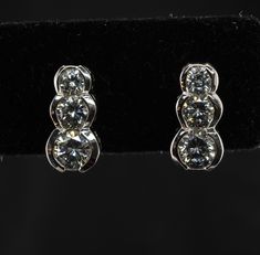 Three Stone Earrings, Genuine Diamond Earrings, Vintage Earrings, 14K White Gold Earrings, Natural Diamond Stud Earrings, Estate Earrings, Everyday Earrings, Elegant Earrings. This vintage pair of earrings is crafted in solid 14K White Gold Three round cut diamonds are .20ct, .15 carat, and .10 carat each = .90 total diamond weight. The diamonds are very clean VS2 clarity and H color. The earrings measure 11mm from top to bottom. They are equipped with long posts and butterfly backs. The pair we Classic Diamond Clip-on Earrings With Brilliant Cut, Wedding Three Stone Earrings In Fine Jewelry, Wedding Three Stone Fine Jewelry Earrings, Wedding Three Stone Fine Earrings, Elegant Three Stone Wedding Earrings, Elegant Three-stone Wedding Earrings, Three-stone Diamond Earrings For Wedding, Elegant Diamond White Three Stone Diamond Earrings, Wedding Diamond Earrings With Three Stones