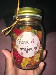 a hand holding a jar filled with gummy bears