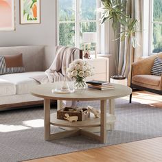 a living room with two couches and a coffee table in front of large windows